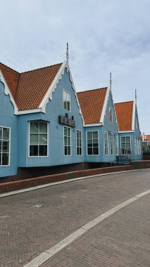 Zaandam, Hollanda - 20 Haziran 2024, Zaandam şehir merkezinde kırmızı çatılı modern mavi evler, ünlü bir manzara ve turistik mekan,