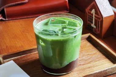 Bir bardak buzlu kibrit yeşil çayı ahşap masaya koyun.