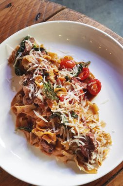 Tabağında et olan makarna manzaralı.