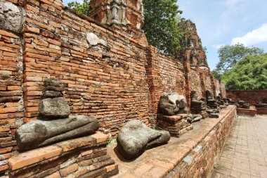 Eski taş harabe Buda heykelleri tuğla duvarın önüne konmuş.