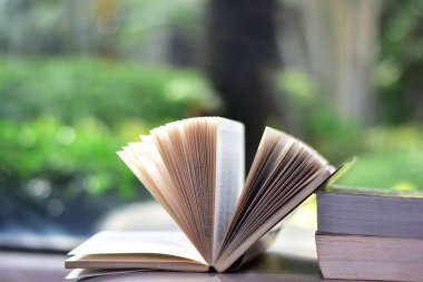 Stack of books in the library and blur bookshelf background, image selective focus at Thailand.