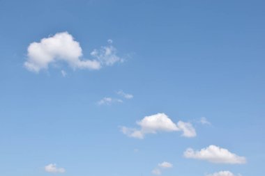 Beyaz bulutlu mavi gökyüzü. Güzel gökyüzü arkaplanı ve duvar kağıdı. Açık bir gün ve güzel bir sabah..  