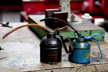 Tayland 'da arkaplanda mühendislik çizimleri olan ahşap masaya yerleştirilmiş iki adet eski metal taşıyıcı..