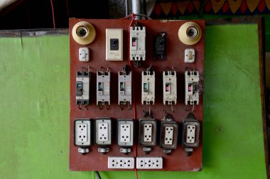 BANGKOK, THAILAND - 1 Temmuz 2024: Elektrik dolgu panelleri evin içindeki tahta bir tahtanın üzerinde sırayla dizildi. Yangını her zaman önleme kavramı.