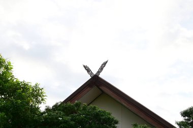 Tayland 'da mavi gökyüzü arkaplanlı Tayland evlerinin kapılarını oyulmuş Kalae adında ahşap bir kapı süslüyordu..