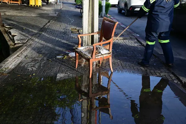 Sadece ahşap iskeleti kalmış eski, lüks bir ahşap sandalye. Sabah Tayland 'da bir elektrik direğinin yanındaki çöp yığınının içine bırakılmış..