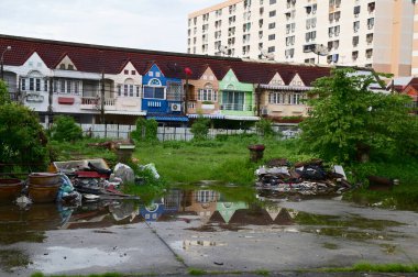 BANGKOK THAILAND - 23 Temmuz 2024: Suda yansıması olan güzel renkli kasaba evi ve Tayland 'da mavi gökyüzü arka planına sahip çöp parçaları.