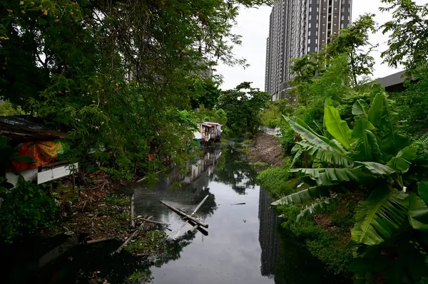 stock image BANGKOK, THAILAND  - July 29, 2024: The Old Wooden House on both sides of the sewage canal with blue sky background in Bangkok, Thailand.