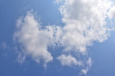 Beyaz bulutlu parlak mavi gökyüzü. Güzel gökyüzü arkaplanı ve duvar kağıdı. Açık bir gün ve güzel bir sabah..  