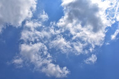 Beyaz bulutlu parlak mavi gökyüzü. Güzel gökyüzü arkaplanı ve duvar kağıdı. Açık bir gün ve güzel bir sabah..  