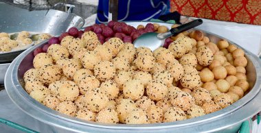 Tayland 'da sokak yiyecekleri için gümüş metal tepsiye yerleştirilmiş Golden Fried Susame Balls (Tayland tatlısı) yakın plan. Sağlıklı gıda konsepti, seçici yumuşak odaklanma.