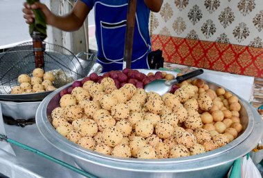 Tayland 'da sokak yiyecekleri için gümüş metal tepsiye yerleştirilmiş Golden Fried Susame Balls (Tayland tatlısı) yakın plan. Sağlıklı gıda konsepti, seçici yumuşak odaklanma.