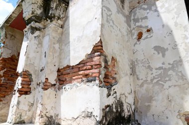 Beton bir binanın eski çatlak duvarı. Kırmızı tuğla duvarın bir kısmı Tayland 'da terk edilmiş..