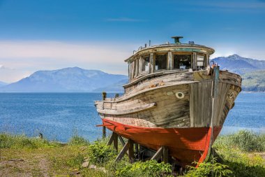 A rotting abandoned old wooden fishing boat in Icy Strait Point, Alaska clipart