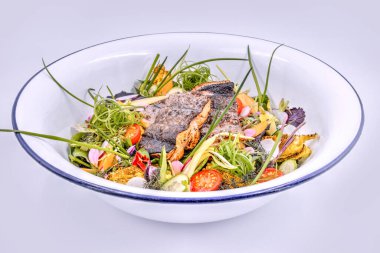 Beyaz kasede ızgara balık filetosu ile taze bahçe salatası.