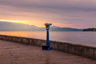 Garda Gölü üzerinde gün doğumu, turistlerin göle bakmasını bekleyen dürbünler.