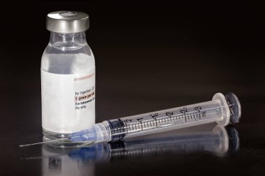 Serum, şişede aşı ve iğne.