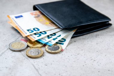 Avrupa parası olan siyah bir parti. Ticaret konsepti için deri cüzdanda faturalar ve madeni paralar.