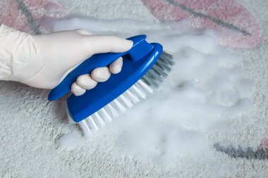 Temizlik için lastik eldiven ve fırça verin. Yerleri temizlemek için plastik mavi fırça. Ev temizliği kavramı.