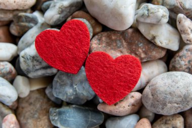 Nehrin yakınındaki çakıl taşlarının üzerinde iki güzel, kırmızı kupa. Romantik aşk geçmişi.