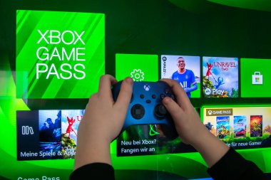 Joystick kumandası elinde. Oyun konsolları Xbox X ve Xbox Serisi S oyun oynamak için kullanılır..