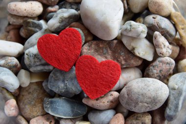 Nehrin yakınındaki taşların üzerinde parlak, kırmızı kalpler. Doğal ve romantik bir geçmiş..