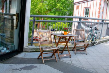 Cafe açık havada. Nehir kenarında, Almanya 'da yaz güneşinin altında sandalyeler ve masalar. Yaz kafesi veya restoranı için mobilya dizaynı.