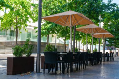 Cafe açık havada. İspanya 'da yaz güneşinin altında sandalyeler ve masalar. Yaz kafesi veya restoranı için mobilya dizaynı.