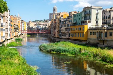 Tarihi evleri olan güzel bir cadde, küçük nehrin yakınındaki eski kasabanın merkezinde pencereler. İspanya, Girona.
