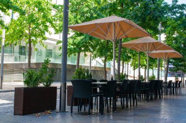 Cafe açık havada. İspanya 'da yaz güneşinin altında sandalyeler ve masalar. Yaz kafesi veya restoranı için mobilya dizaynı.
