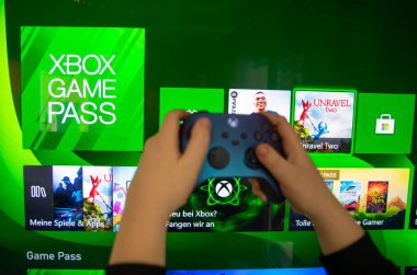Joystick kumandası elinde. Oyun konsolları Xbox X ve Xbox Serisi S oyun oynamak için kullanılır..
