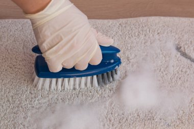 Yerleri temizlemek için plastik mavi fırça. Ev temizliği konsepti. Eldivenli el.