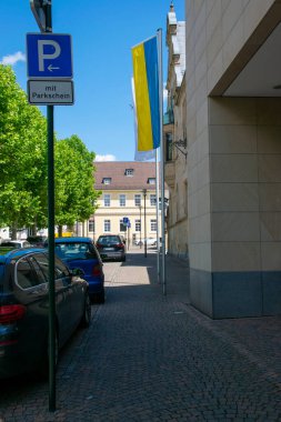 Ukrayna bayrağı, evler, arabalar, pencereler, eski şehrin merkezinde taştan yollar olan boş bir sokak. Almanya.