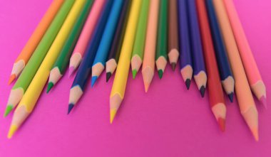 Pembe arka planda renkli kalemler. Kapatın. Tasarım konsepti.