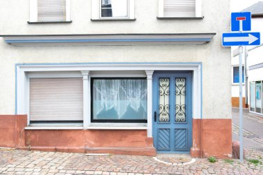 Cam pencereli eski mavi kapı gri bir eve açılıyor. Almanya 'da evleri olan ve şarkı söyleyen bir sokak..