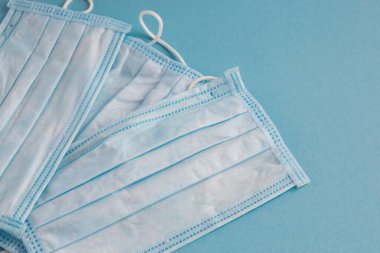 Mavi arka planda yüz için tıbbi maske. Kirliliğe ve virüs korumasına karşı antibakteriyel. Covid-19 - tüm dünyada koronavirüs enfeksiyonu. Sağlık hizmetleri.