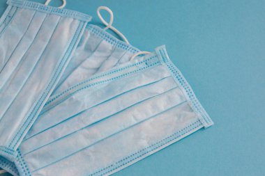 Mavi arka planda yüz için tıbbi maske. Kirliliğe ve virüs korumasına karşı antibakteriyel. Covid-19 - tüm dünyada koronavirüs enfeksiyonu. Sağlık hizmetleri.