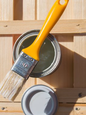 Beyaz boya ve boya fırçası, arka planda tadilat ve yeniden yapılanma için. Ahşap masa.