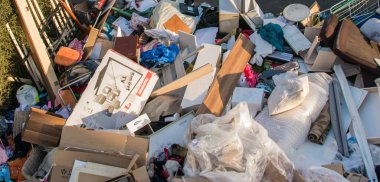 Evin yakınındaki bir şehirde israf. Eski ahşap mobilyaları, oyuncakları, kutuları, sokakta plastik torbaları ve Almanya 'da bahar güneşli çöplük gününde yeşil çimenleri olan büyük bir çöp.. 