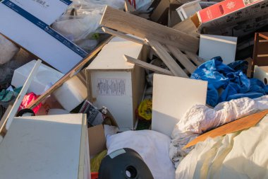 Eski ahşap mobilyaları, oyuncakları, kutuları, sokakta plastik torbaları ve Almanya 'da bahar güneşli çöp atma gününde yeşil çimenleri olan büyük bir çöp. Evin yakınındaki bir şehirde çok fazla atık var.. 