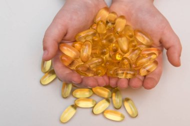 Omega 3 vitamini bej arka planda kapsüllerde balık yağı.