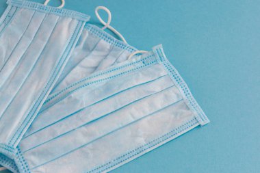 Mavi arka planda yüz için tıbbi maske. Kirliliğe ve virüs korumasına karşı antibakteriyel. Covid-19 - tüm dünyada koronavirüs enfeksiyonu. Sağlık hizmetleri.