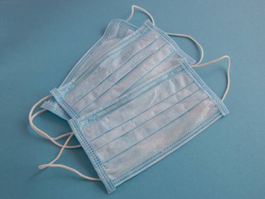 Mavi arka planda yüz için tıbbi maske. Kirliliğe ve virüs korumasına karşı antibakteriyel. Covid-19 - Coronavirüs enfeksiyonu tüm dünyada.