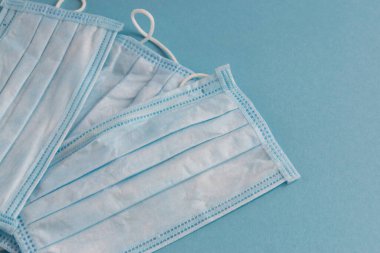 Mavi arka planda yüz maskesi. Kirliliğe ve virüs korumasına karşı antibakteriyel. Covid-19 - Coronavirüs enfeksiyonu tüm dünyada.