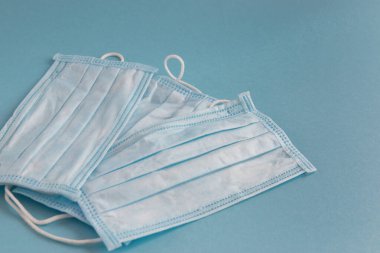 Mavi arka planda yüz için tıbbi maske. Kirliliğe ve virüs korumasına karşı antibakteriyel. Covid-19 - tüm dünyada koronavirüs enfeksiyonu. Sağlık hizmetleri.