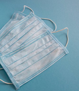 Mavi arka planda yüz için tıbbi maske. Kirliliğe ve virüs korumasına karşı antibakteriyel. Covid-19 - tüm dünyada koronavirüs enfeksiyonu. Sağlık hizmetleri.