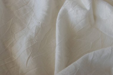 Bej pamuklu, yumuşak desenli giysiler. Tekstil kumaş arkaplanı.