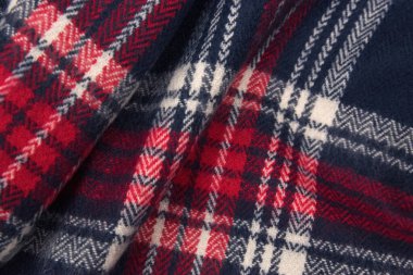 Mavi, beyaz, kırmızı kafes dokusu. Kış kaşmir atkısı. Tekstil koyu renkli örgü arka plan.