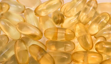 Beyaz arka planda kapsüllerdeki Omega 3 vitamini yağı.