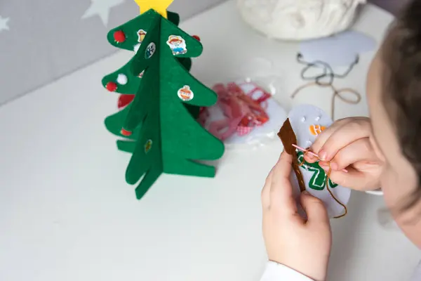 stock image The hand of the child make snowman and christmas tree with needle, thread for christmas greeting card. Hobby concept. Handmade.